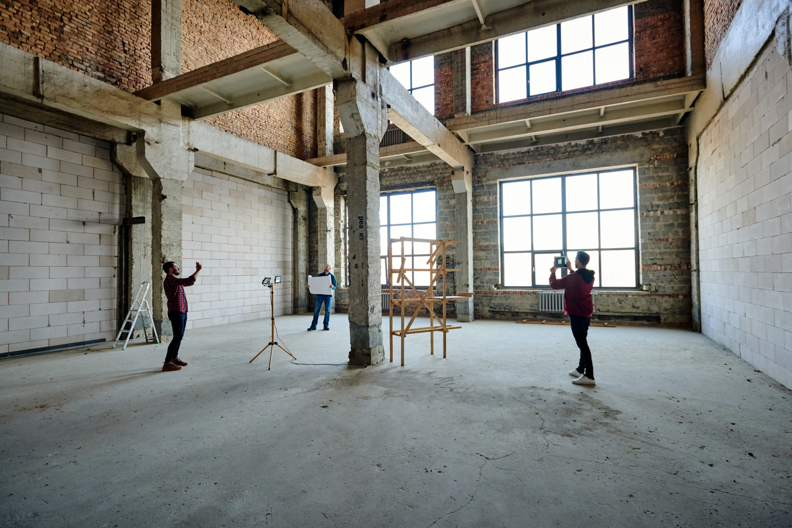 Two young contractors photographing unfinished structure inside building Full Commercial Dilapidations In Portsmouth